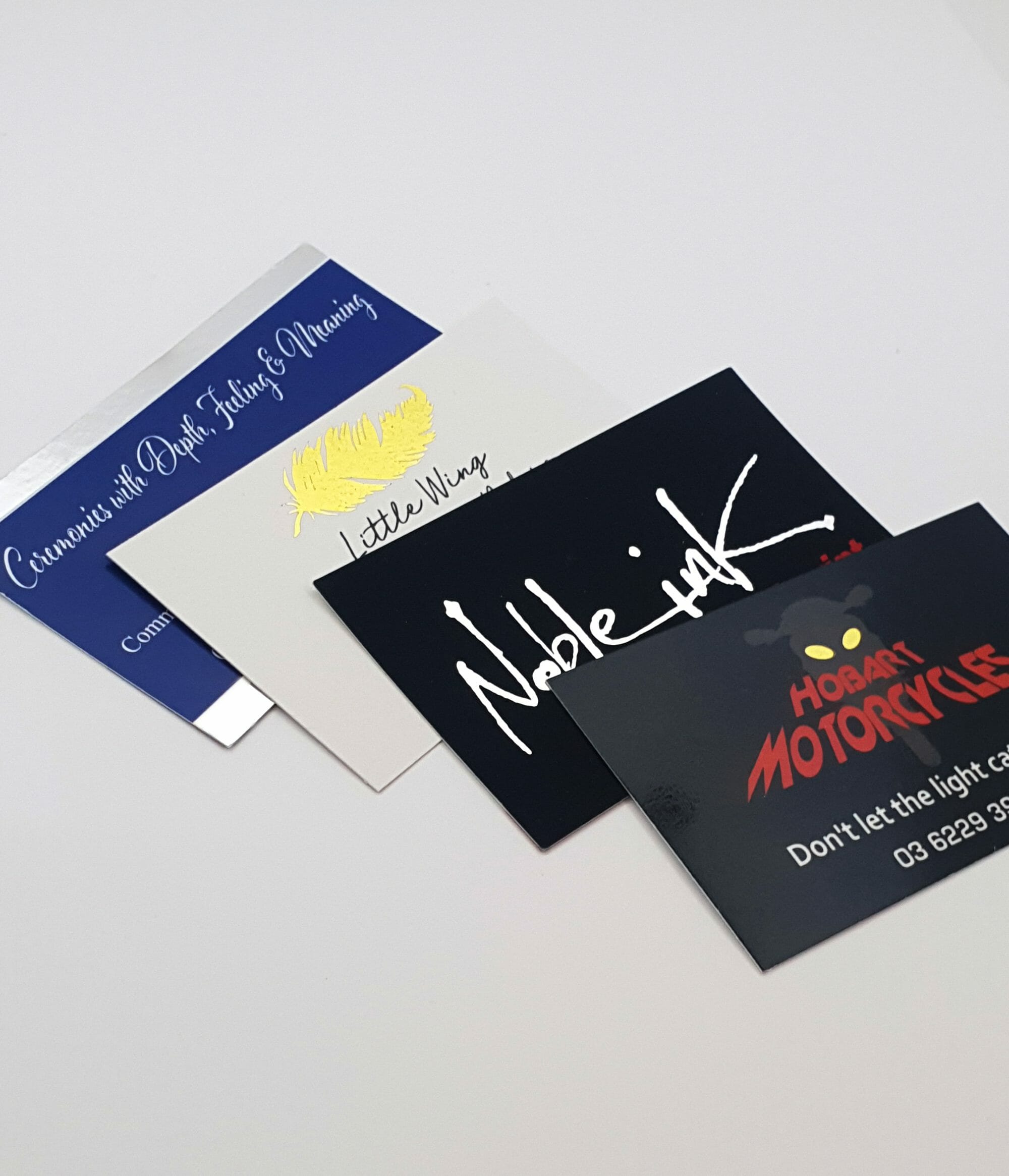 A group of business cards on a white surface. Noble Ink